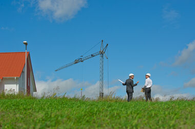 e-netz-Mitarbeiter führen ein Gespräch im Grünen über eine Baulanderschließung