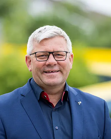 Bürgermeister Volker Oehlenschläger im Anzug lächelt freundlich in die Kamera.