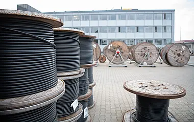 Kabeltrommeln mit schwarzen Stromkabeln liegen am Hauptlager der e-netz Südhessen bereit