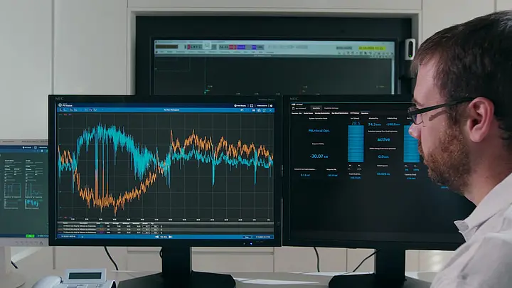 Techniker analysiert Daten auf mehreren Bildschirmen in einem Labor.