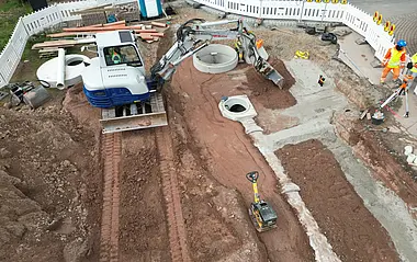 Luftaufnahme zeigt eine Baustelle mit einem Bagger.