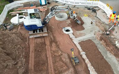 Luftaufnahme zeigt eine Baustelle mit einem Bagger.