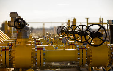 Industrielle Gasrohrleitungen mit Ventilen in einer Landschaft.
