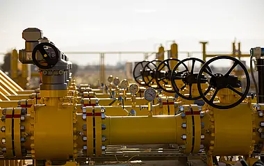 Industrielle Gasrohrleitungen mit Ventilen in einer Landschaft.