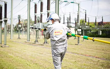 e-netz-Monteur trägt einen Hochspannungsprüfer in einer Umspannanlage