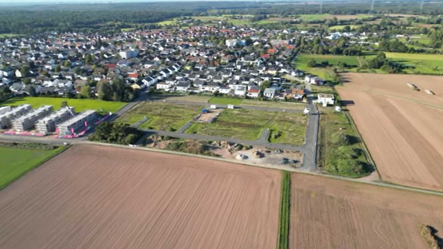 Baustelle mit Wohnbebauung und angrenzenden Feldern aus der Vogelperspektive.