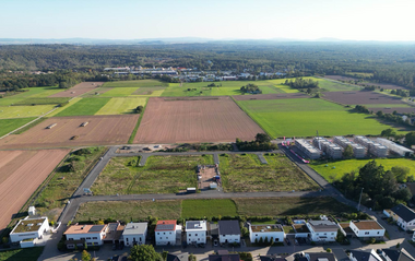 Luftaufnahme zeigt Wohnhäuser und landwirtschaftliche Flächen in der Umgebung.