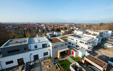Moderne Wohngebäude mit Flachdächern und Blick auf die Stadtlandschaft.