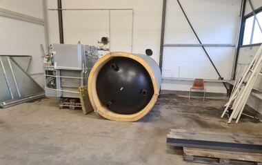 Mobile Pelletheizung steht in einer Werkshalle.