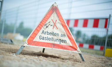 Baustelle wird durch ein Hinweisschild Arbeiten an Gasleitungen gekennzeichnet