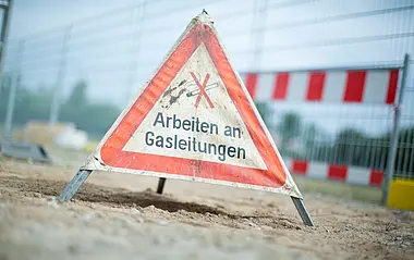 Baustelle wird durch ein Hinweisschild Arbeiten an Gasleitungen gekennzeichnet