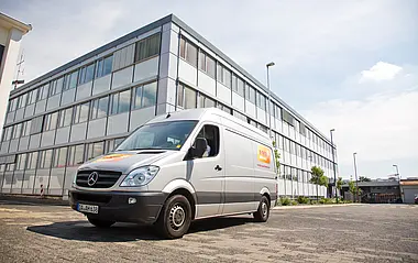 Montagefahrzeug fährt auf dem Betriebsgelände am Hauptgebäude der e-netz Südhessen vorbei