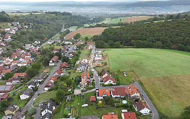 Luftaufnahme zeigt eine Wohngegend mit Häusern, Gärten und Straßen.