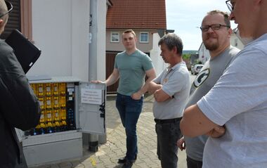 Techniker inspizieren eine elektrische Verteileranlage im Freien.