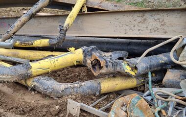 Beschädigte Rohre liegen auf einer Baustelle.