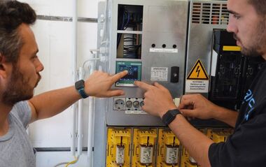 Zwei Mitarbeiter beim Einbau von Multimessgeräten. 