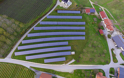Solarpark auf einem Feld, aufgenommen aus der Vogelperspektive.