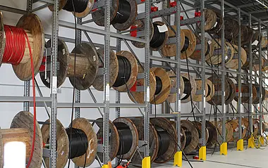 Kabelrollen sind ordentlich in einem Lagerregal gestapelt und gelagert.