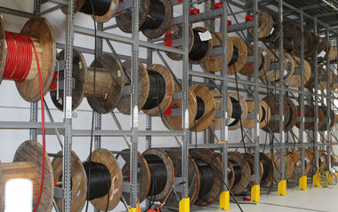 Kabelrollen sind ordentlich in einem Lagerregal gestapelt und gelagert.