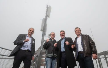 Vier Männer, im Hintergrund die Funkantenne auf dem neuen Trommturm in Rimbach im Nebel.