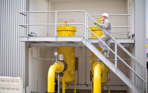e-netz-Monteur betritt eine Gasanlage über eine Außentreppe
