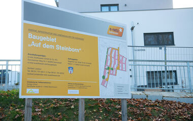 Werbeschild für das Neubaugebiet „Auf dem Steinborn“ mit Grundrissplan und Kontaktinformationen.