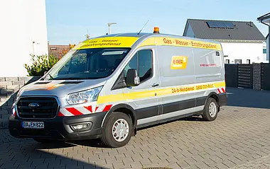 Wartungsfahrzeug der e-netz Südhessen steht vor einem Wohnhaus.