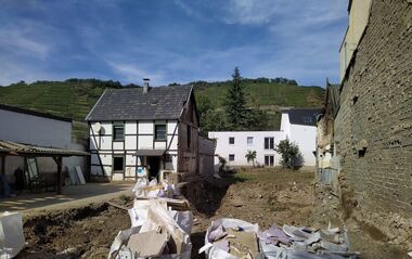 Mehrere Schutthaufen vor einem Fachwerkhaus in Walporzheim nach der Flutkatastrophe.