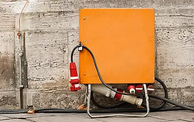 Baustrom-Verteilerkasten vor einer grauen Wand