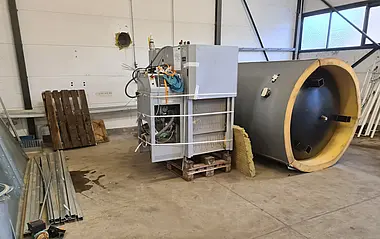 Das Bild zeigt eine mobile Pelletheizung in einer Werkshalle.