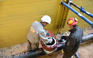 Zwei Monteur wenden auf einer Baustelle das Stopple-Verfahren an, um Gashochdruckleitung zu sperren