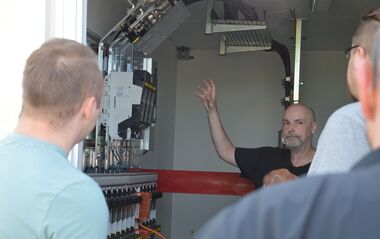 Ein Mann erklärt die Funktion einer Pilotanlage der Niederspannungsnetze.